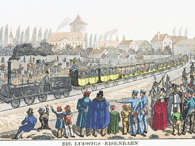 Eine Gruppe von Menschen, die um einen Zug auf einem Gleis stehen, mit einigen im Zug und anderen auf dem Boden, in der Nähe von Gebäuden und Bäumen, mit Text, der unten lautet "Ludwigs-Eisenbahn, der erste Bahnhof in Deutschland".