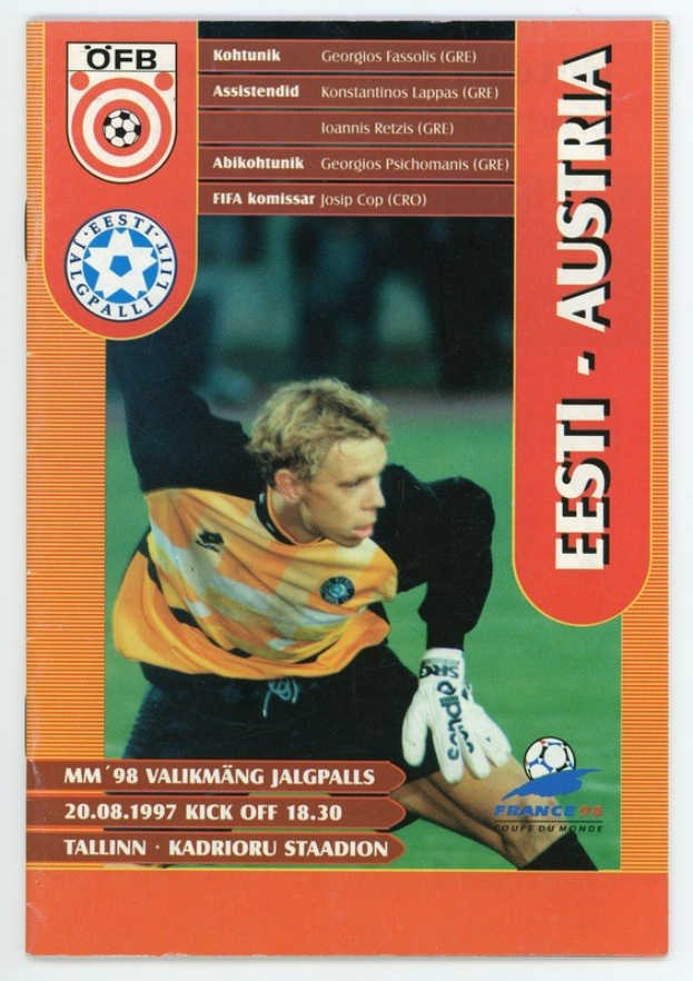 Eine Fußballkarte von der FIFA-Weltmeisterschaft 1998 in Deutschland, die einen Spieler in einem Trikot mit entschlossener Miene zeigt, vor einem hellblauen Himmel mit weißen Wolken, mit einem Logo und Text auf der Karte.