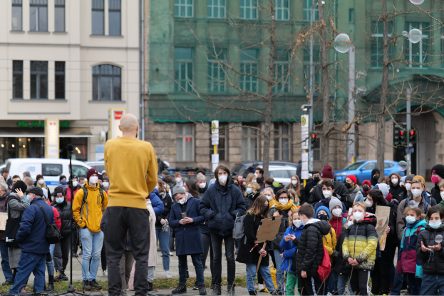 Eine Gruppe von Menschen, die vor einer Menge mit Schildern und Masken steht und ein Mikrofonständer im Vordergrund zu sehen ist, in Berlin, Deutschland, protestiert gegen die Coronavirus-Pandemie.