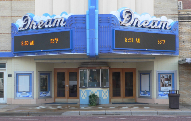Außenansicht des Dream Theaters in St. Louis, Missouri, mit Glastüren und -fenstern, einem Namen auf einem Schild, einem Müllbehälter, einem Topf mit einer Pflanze und einer Straße im Vordergrund.
