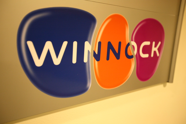 Leuchtend buntes "Winnock"-Schild an einer Wand angebracht, das einen Börsenplatz anzeigt.