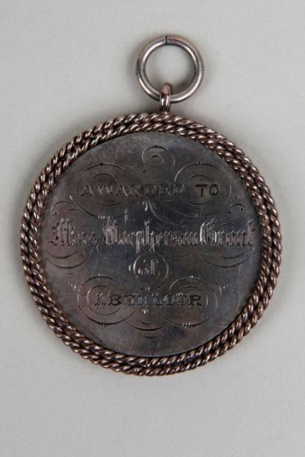 Silberne Medaille mit schwarzem Text "Ausgezeichnet an den Metropolitan Council" an einer Schnur, mit einem dekorativen Rand.