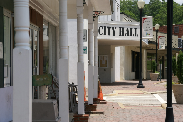 Stadtverwaltung von Gebäuden, Straßeninfrastruktur, Fahrzeugen und Vegetation umgeben