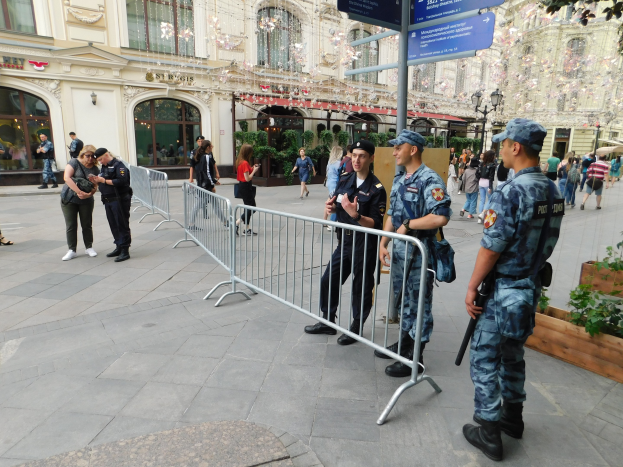 Polizisten in Uniform stehen hinter Barrieren einer Menge gegenüber, von der einige Mützen tragen und Waffen halten, während sie eine Anti-Terror-Operation in Wien, Österreich, durchführen.