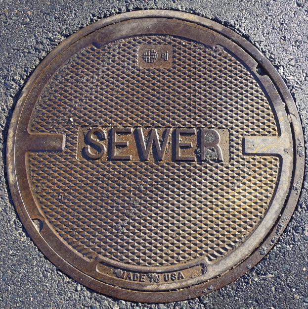 Metall-Schachtobjekt auf der Straße beschriftet mit 'Kanal'.