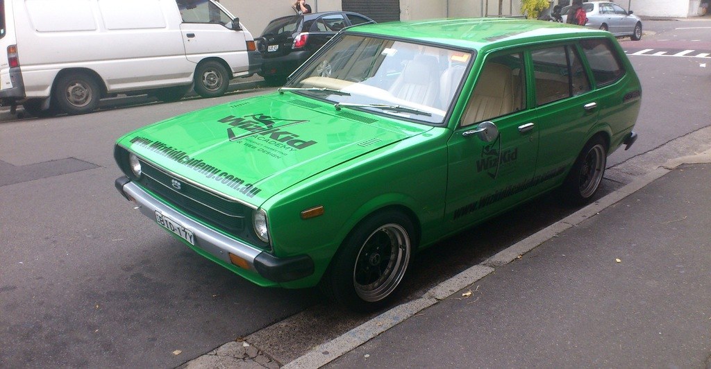 Eine Person in der Nähe von Fahrzeugen auf einer Straße.