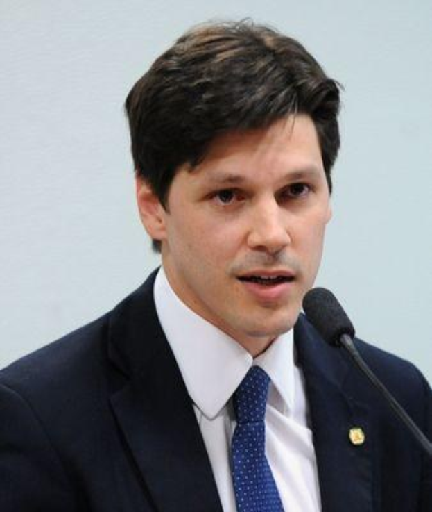 Ein Mann im Anzug spricht in ein Mikrofon an einem Podium, wahrscheinlich zur Genehmigung eines Internetsperrgesetzes durch die Regierung.