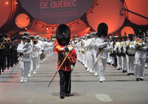 Eine Gruppe uniformierter Personen marschiert während der Eröffnungszeremonie des Montreal International Festival of Military Bands.